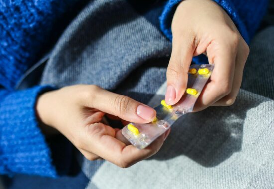 Person taking out yellow pills from packet